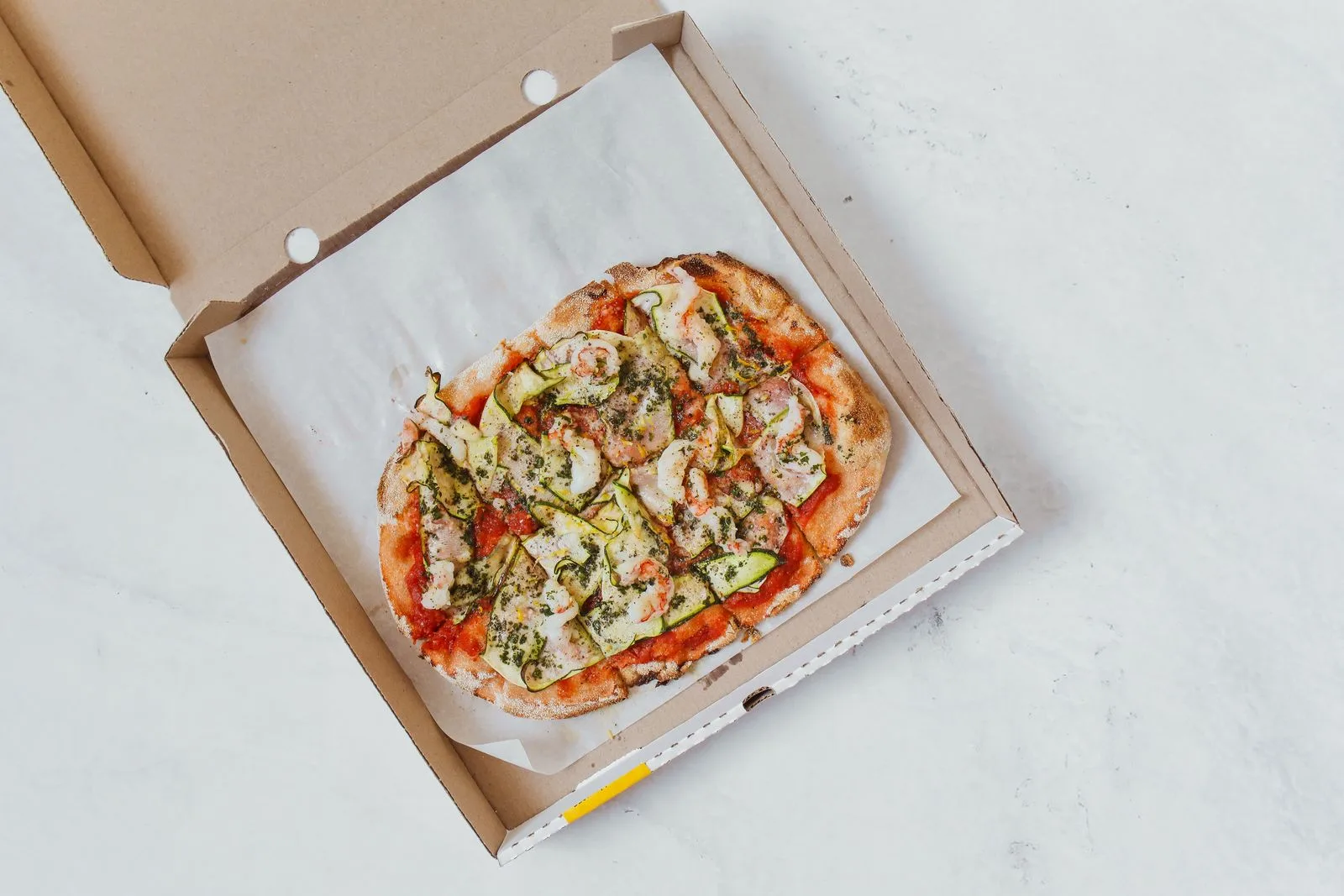 Pizza in an open cardboard takeaway box